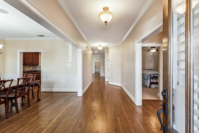 foyer with ornamental molding and dark hardwood / wood-style flooring