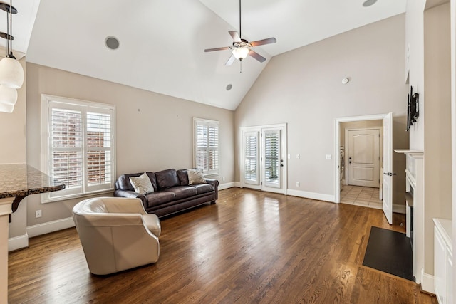 living room with ceiling fan, high vaulted ceiling, and dark hardwood / wood-style flooring