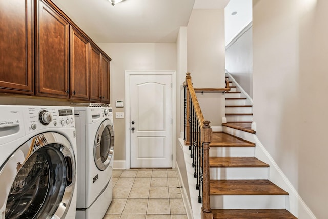 laundry room with cabinets, independent washer and dryer, and light tile patterned flooring