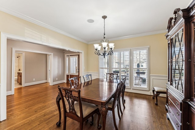 dining room with wood-type flooring, ornamental molding, and a notable chandelier