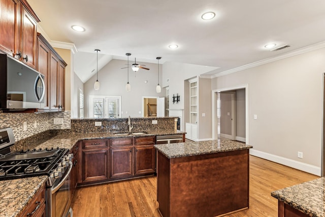 kitchen featuring decorative light fixtures, tasteful backsplash, dark stone counters, a kitchen island, and stainless steel appliances