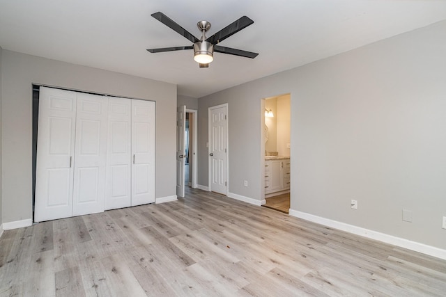 unfurnished bedroom featuring a closet, ceiling fan, light hardwood / wood-style floors, and ensuite bath