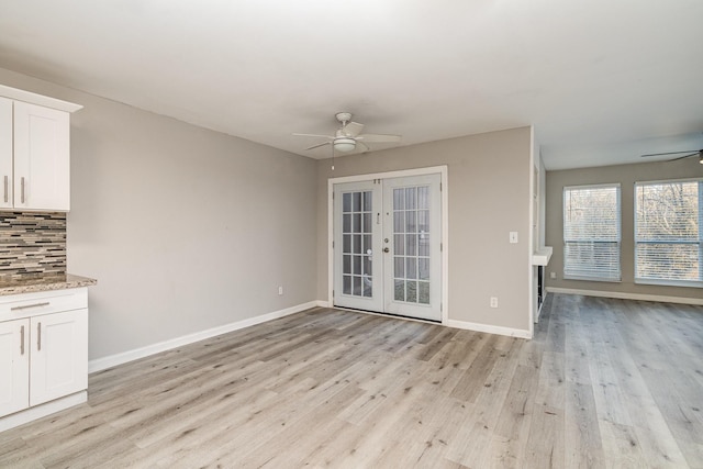 unfurnished living room with light hardwood / wood-style flooring, ceiling fan, and french doors