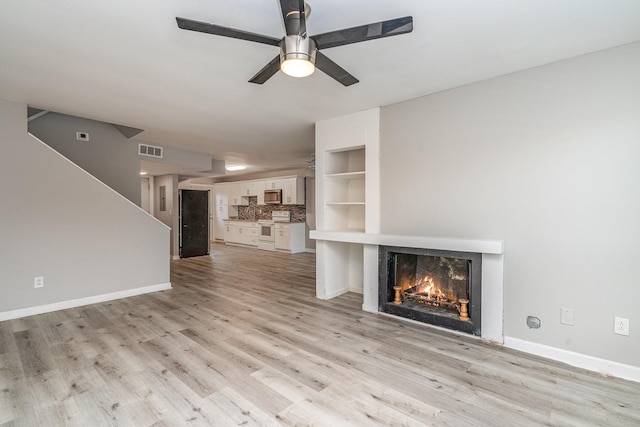 unfurnished living room with light wood-type flooring and ceiling fan