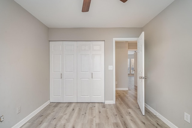 unfurnished bedroom featuring light hardwood / wood-style floors, a closet, and ceiling fan