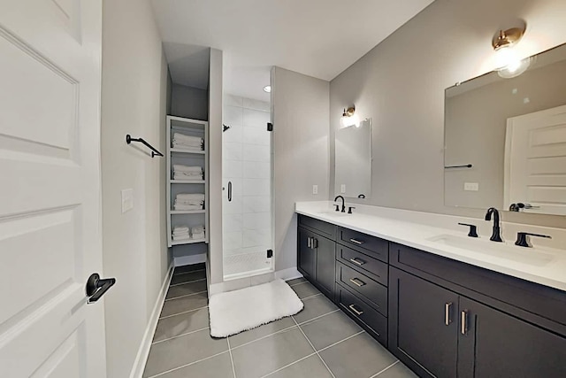 bathroom with tile patterned flooring, a shower with shower door, and vanity