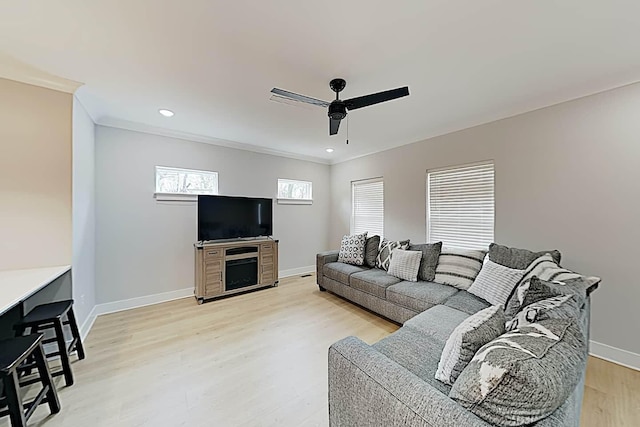 living room with ceiling fan, crown molding, and light hardwood / wood-style floors