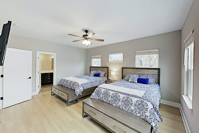 bedroom with light hardwood / wood-style floors, ensuite bath, and ceiling fan