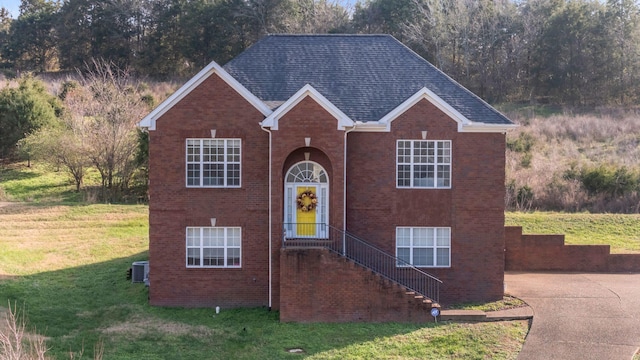 view of front facade with central air condition unit and a front lawn