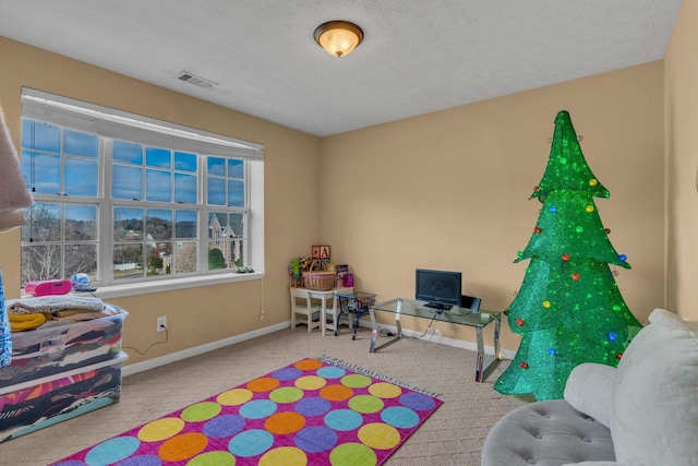 game room with a textured ceiling and light carpet