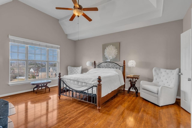 bedroom featuring ceiling fan, hardwood / wood-style floors, and vaulted ceiling