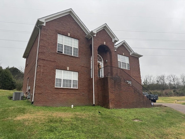 view of property exterior with central air condition unit and a yard