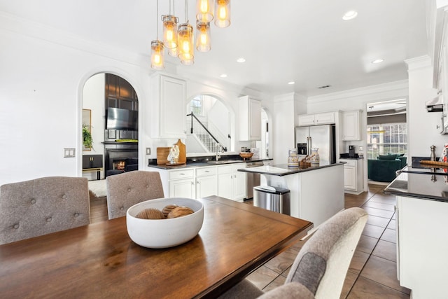 tiled dining room featuring sink, ornamental molding, and a notable chandelier