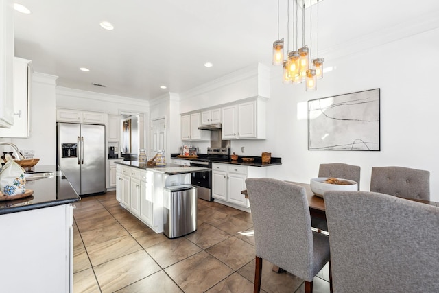 kitchen with a center island, appliances with stainless steel finishes, white cabinetry, sink, and decorative light fixtures