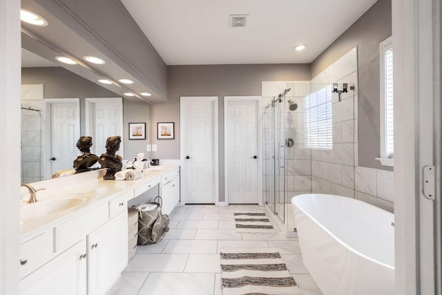 bathroom featuring vanity and independent shower and bath