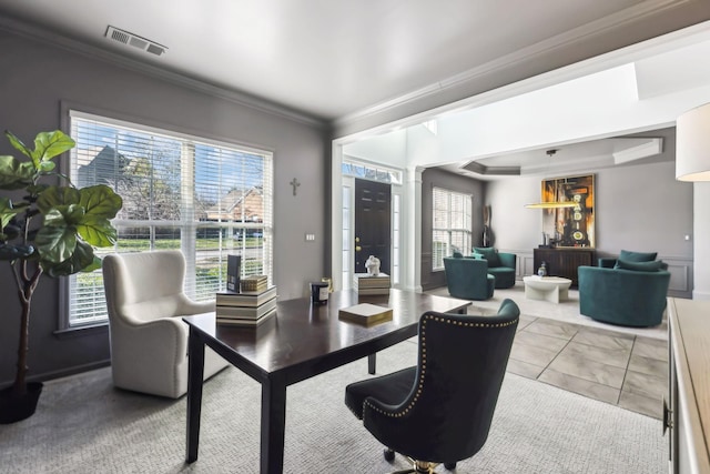 tiled office space featuring plenty of natural light, ornamental molding, and ornate columns