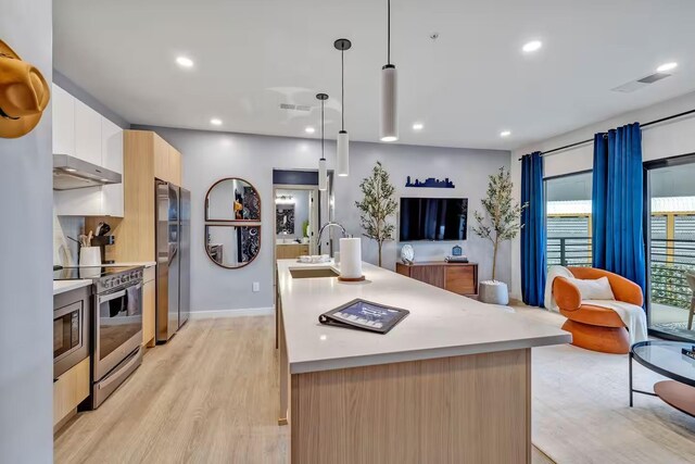 kitchen featuring sink, an island with sink, white cabinets, and stainless steel appliances