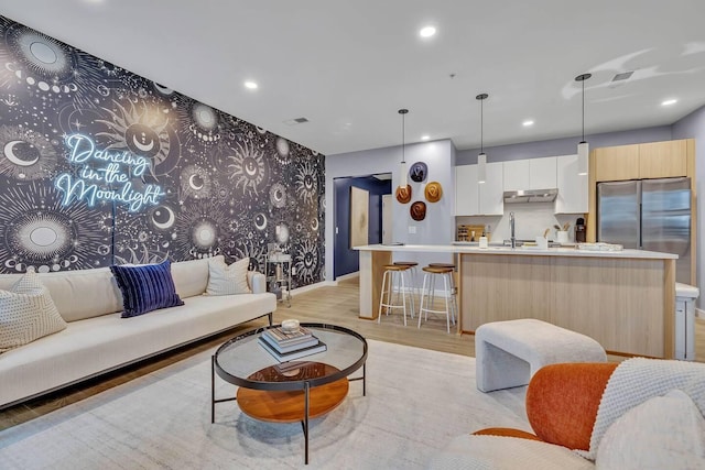 living room with light hardwood / wood-style floors and sink