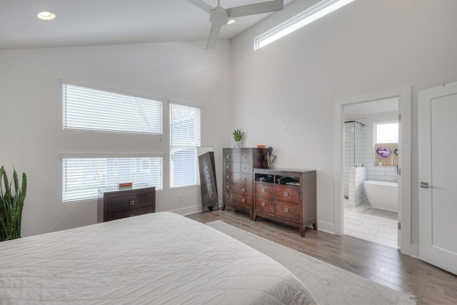 bedroom with multiple windows, light hardwood / wood-style flooring, connected bathroom, and ceiling fan