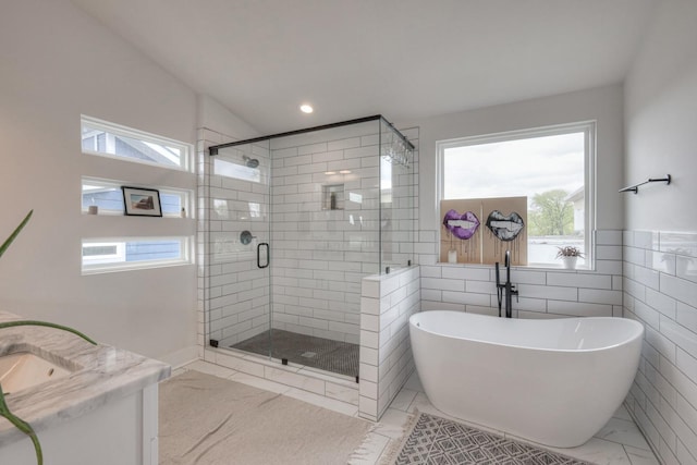 bathroom featuring vanity, vaulted ceiling, tile walls, and separate shower and tub