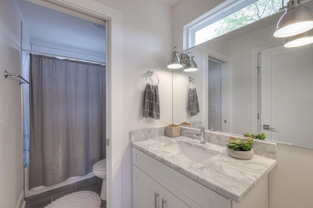 full bathroom featuring toilet, shower / bathtub combination with curtain, and vanity