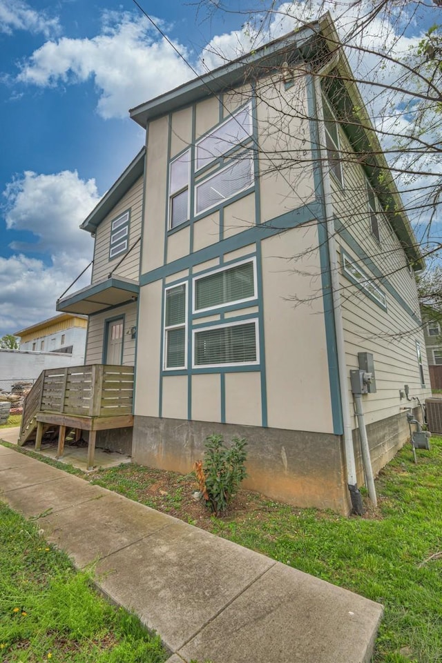 view of side of property featuring a deck and central AC unit