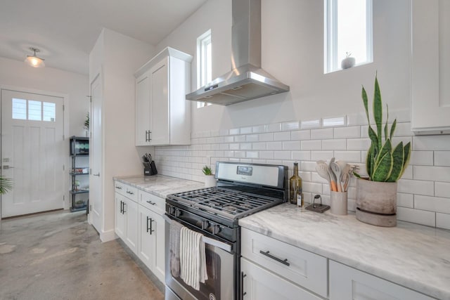 kitchen with light stone countertops, exhaust hood, white cabinetry, tasteful backsplash, and stainless steel range with gas stovetop