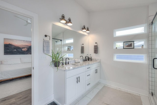 bathroom featuring a shower with door and vanity