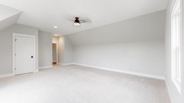 additional living space with ceiling fan, light carpet, and vaulted ceiling