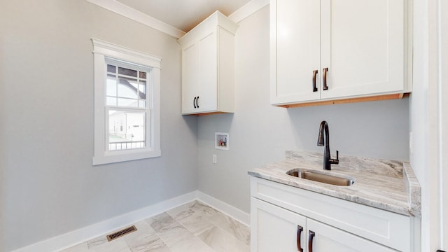 clothes washing area featuring cabinets, sink, ornamental molding, and hookup for a washing machine