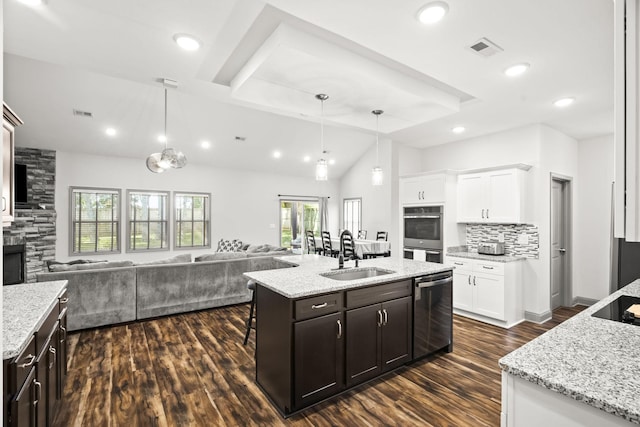 kitchen featuring white cabinets, stainless steel appliances, sink, a center island with sink, and dark brown cabinets