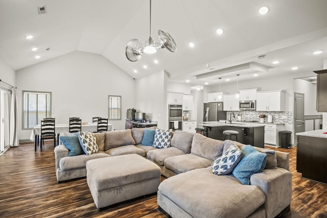 living room featuring high vaulted ceiling, dark wood-type flooring, and sink