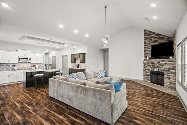 living room featuring a fireplace, vaulted ceiling, and dark hardwood / wood-style flooring