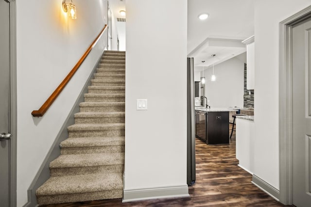 stairs with sink and hardwood / wood-style flooring