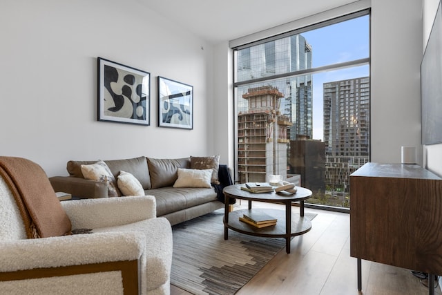 living room featuring light wood-type flooring and floor to ceiling windows