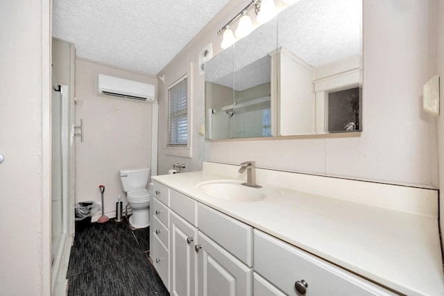 bathroom featuring a textured ceiling, toilet, vanity, and a wall unit AC