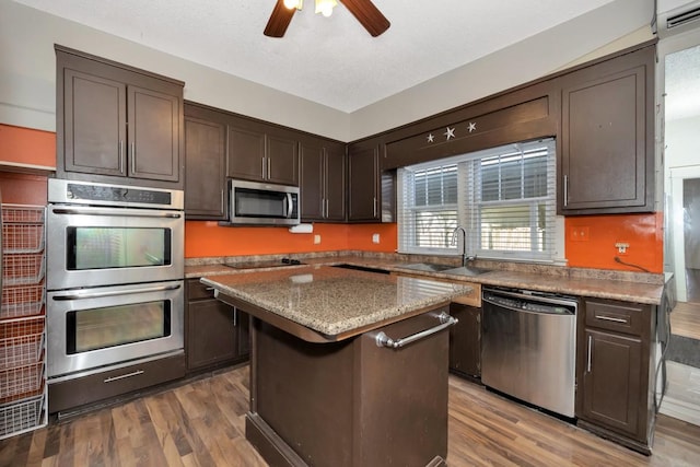 kitchen featuring a center island, wood-type flooring, sink, dark brown cabinets, and stainless steel appliances