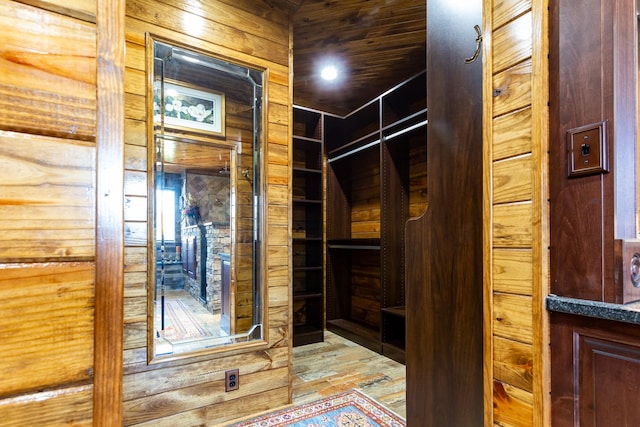 interior space with wooden ceiling, light hardwood / wood-style floors, and wood walls