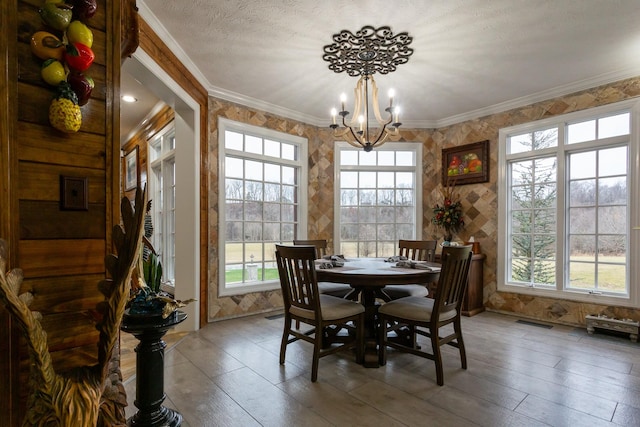 dining room with crown molding, a notable chandelier, and a textured ceiling