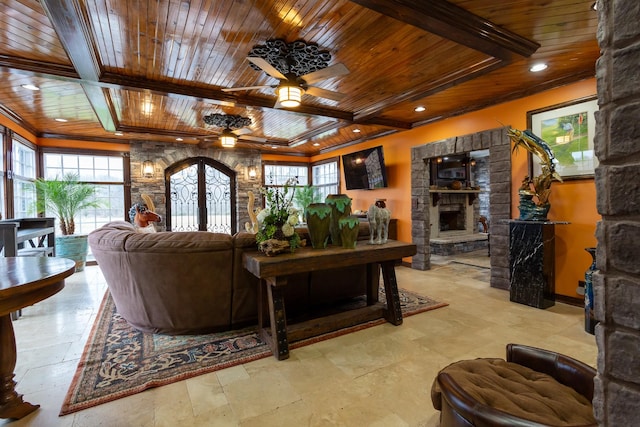 living room featuring ceiling fan, wooden ceiling, and a fireplace