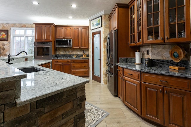 kitchen featuring fridge, crown molding, sink, and dark stone countertops