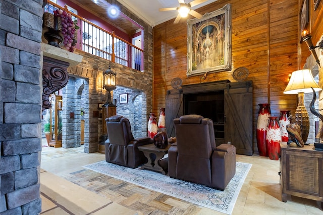 living room with wooden walls, ceiling fan, and a high ceiling