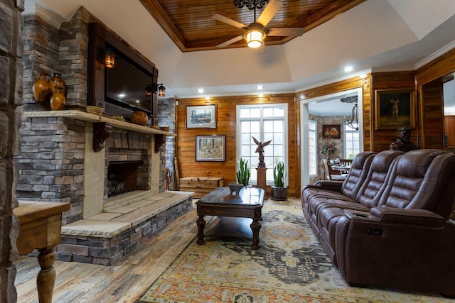 living room with a fireplace, wood walls, wood-type flooring, ornamental molding, and wood ceiling