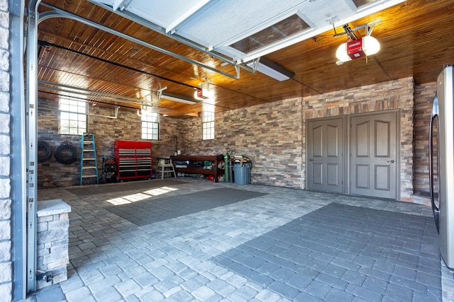 garage featuring a garage door opener, stainless steel fridge, and wooden ceiling