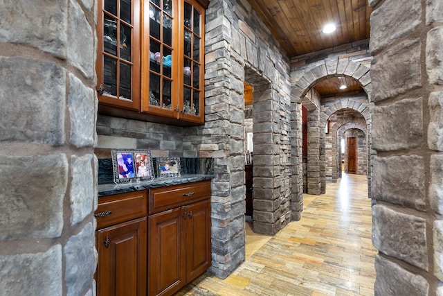 interior space featuring dark stone countertops and wood ceiling