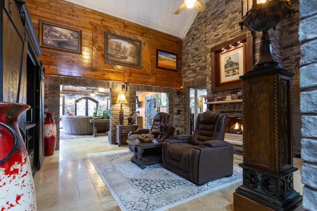 living room with ceiling fan, wooden walls, and high vaulted ceiling