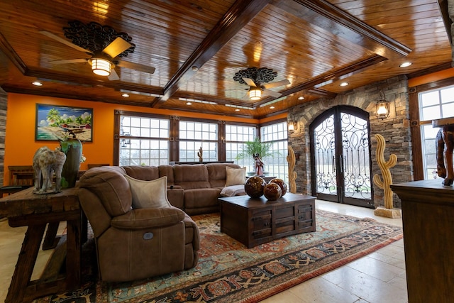 living room featuring beamed ceiling, plenty of natural light, ceiling fan, and french doors