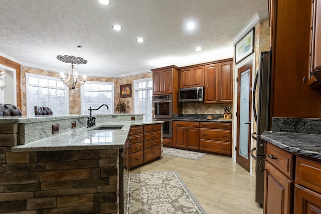 kitchen with sink, ornamental molding, stainless steel appliances, a healthy amount of sunlight, and a spacious island