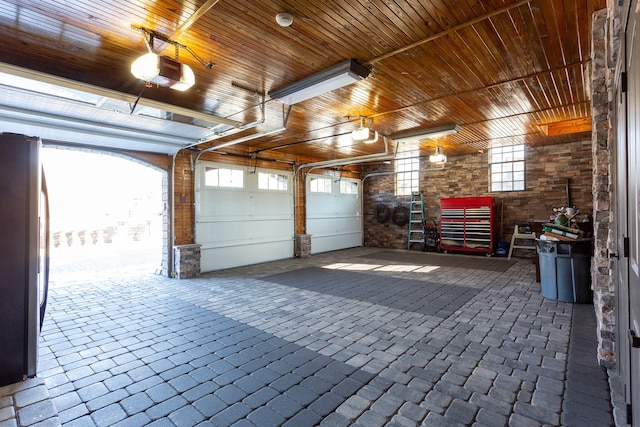 garage with a garage door opener, wooden ceiling, and stainless steel fridge