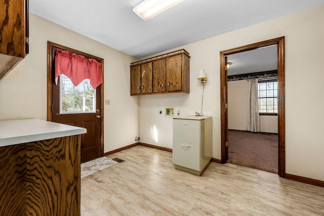 washroom with washer hookup, light wood-type flooring, plenty of natural light, and cabinets